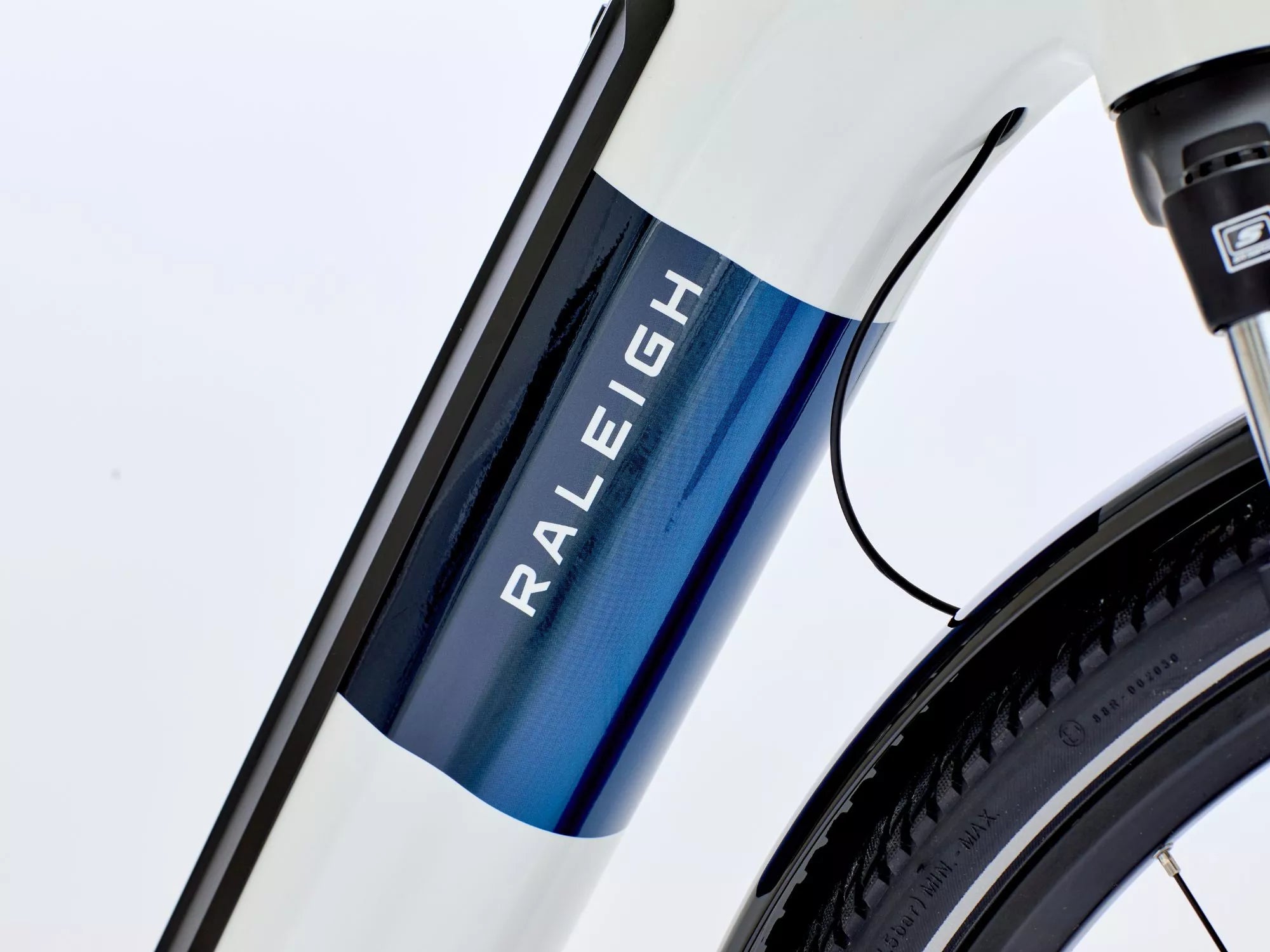 Close-up of a Raleigh bicycle frame with a white and blue design.
