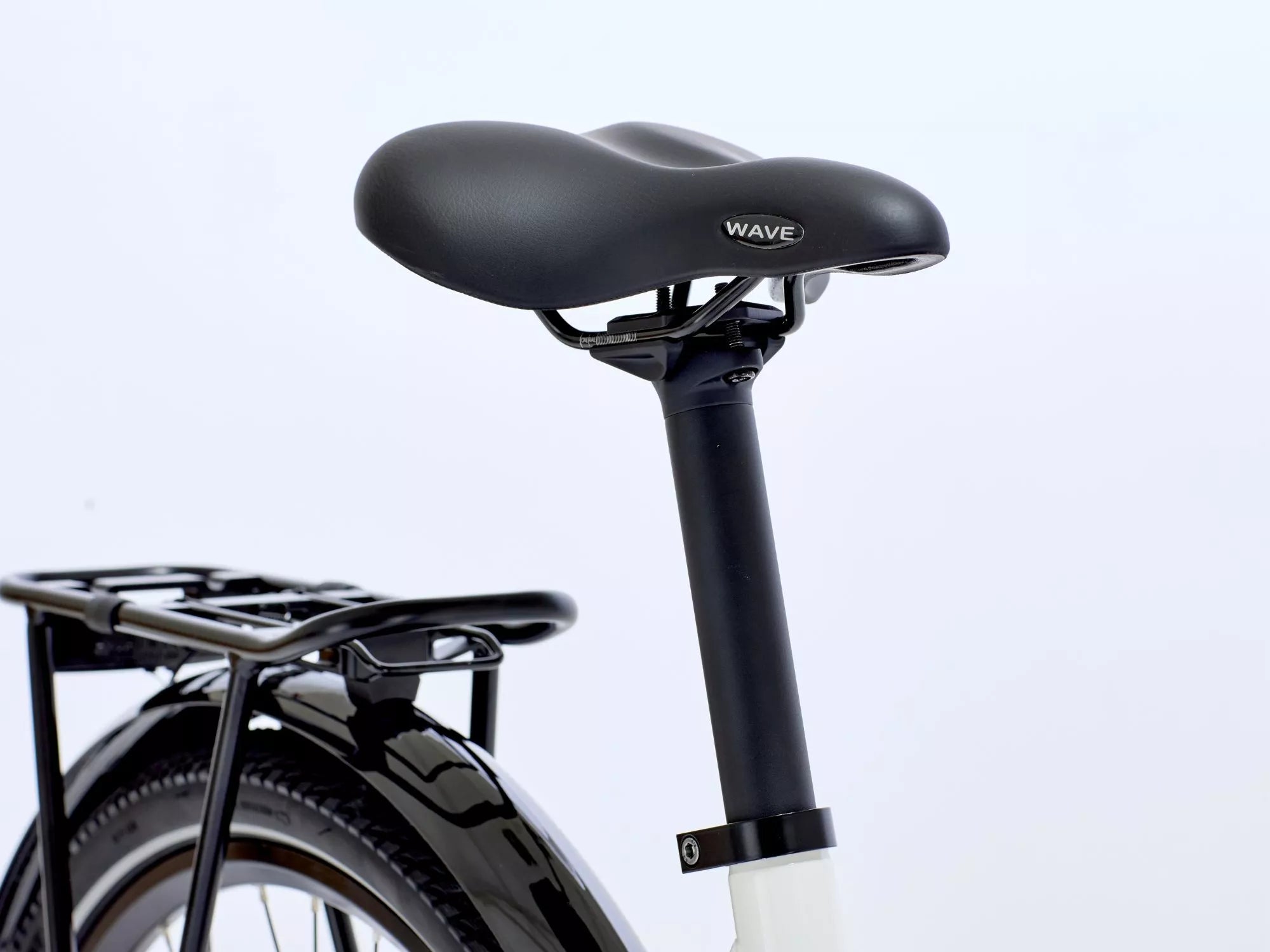 Close-up of a bicycle seat with 'Wave' branding on a light gray. background