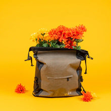 Load image into Gallery viewer, Gray and black Yuba bike bag filled with vibrant orange and yellow flowers, displayed against a bright yellow background.
