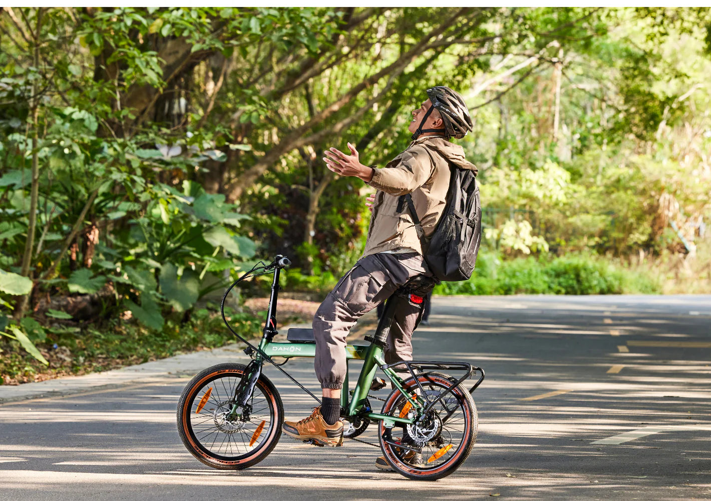 Person riding a bicycle on a road with greenery in the background