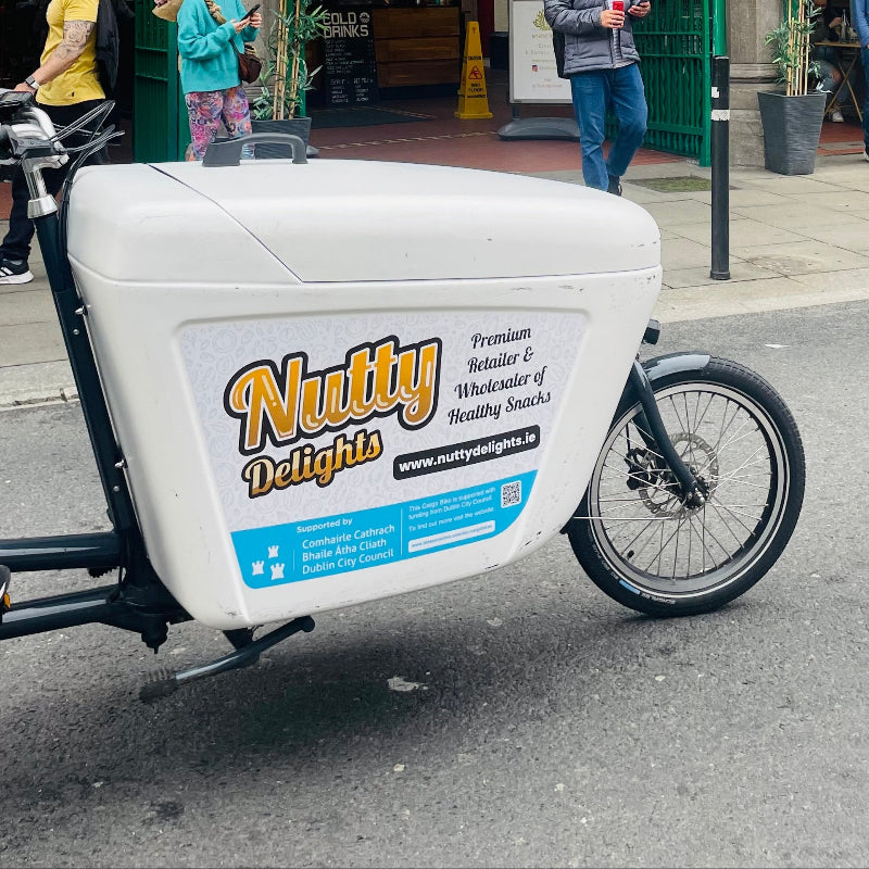 A close-up photo of the branding on a Raleigh Pro e-cargo bike featuring the Nutty Delights logo.