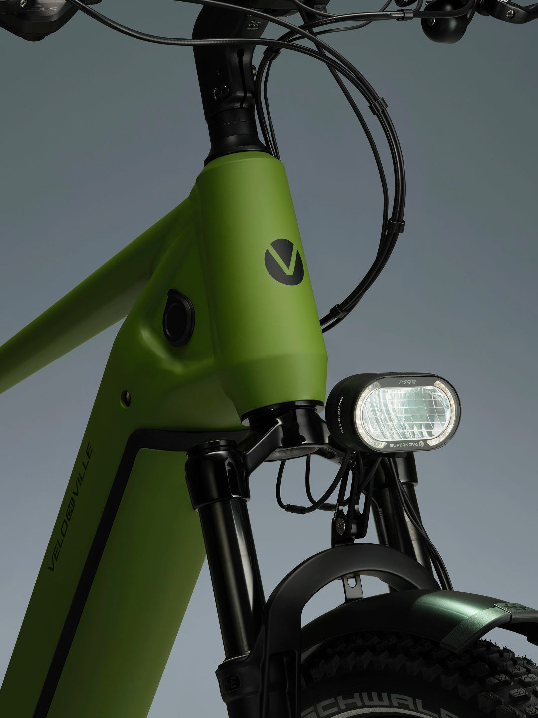 A close-up image showing the detail of the green frame colour of a VELO DE VILLE electric bike.