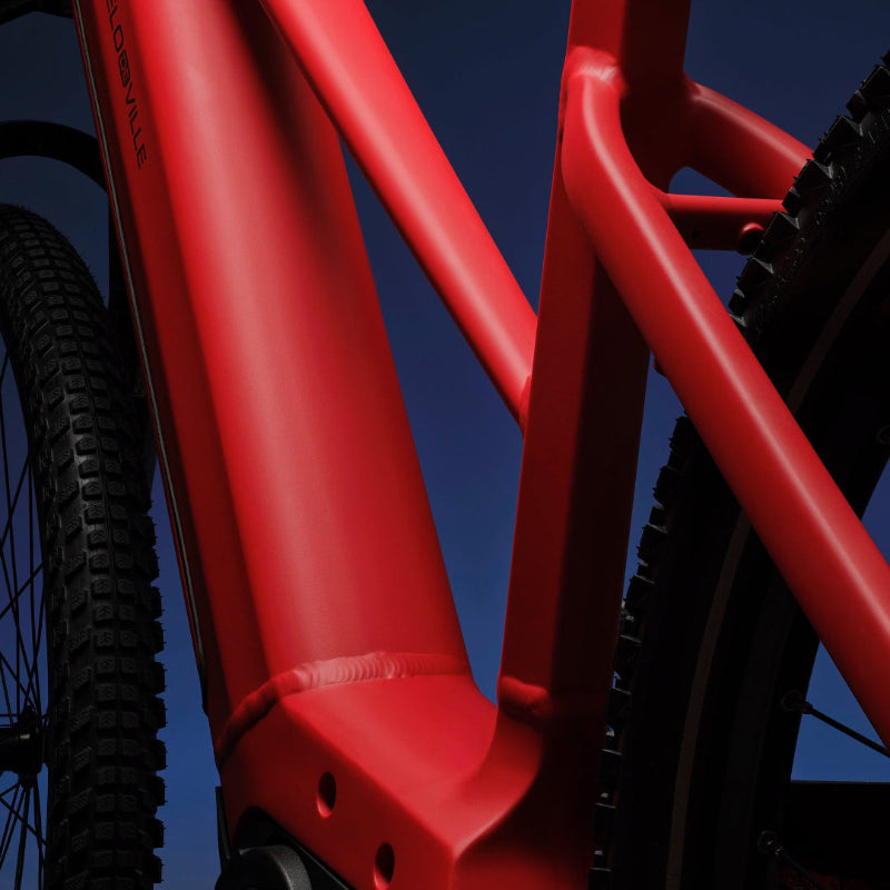 A close-up image showing the detail of the red frame colour of a VELO DE VILLE electric bike.