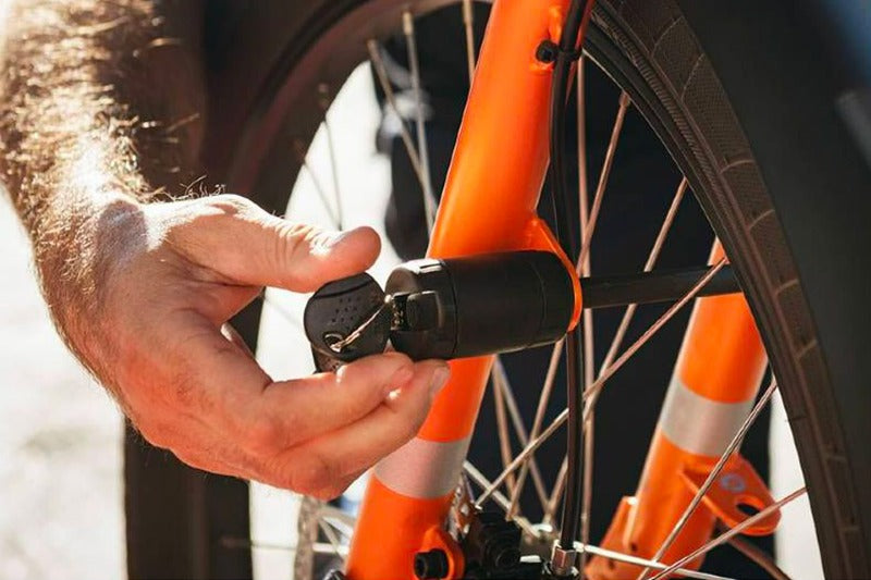 A photo of the Yuba Pin Lock being inserted through the front wheel of a Yuba longtail cargo bike.