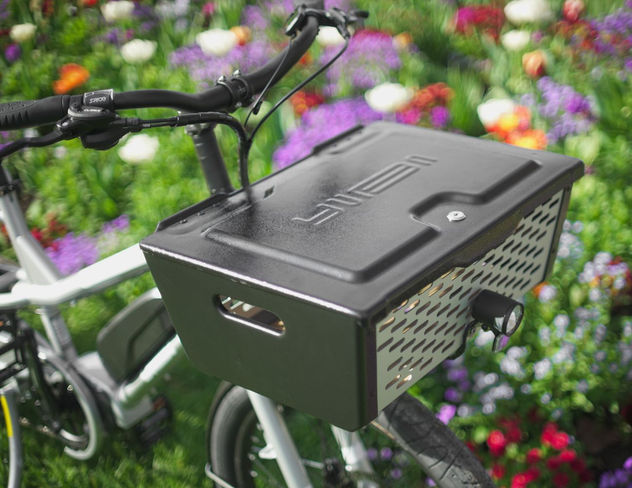 A photo of the Yuba Pot lockable box attached the the front of a Yuba longtail electric cargo bike.