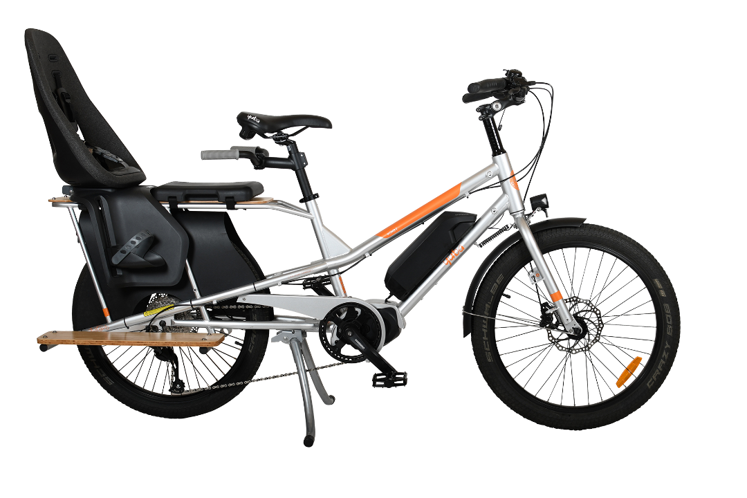 A product image of the Yuba Kombi E5 electric longtail cargo bike which can be hired from LeaseBike. The photo shows the right side of the cargo bike with a child seat and soft sport seat attached to the rear rack.