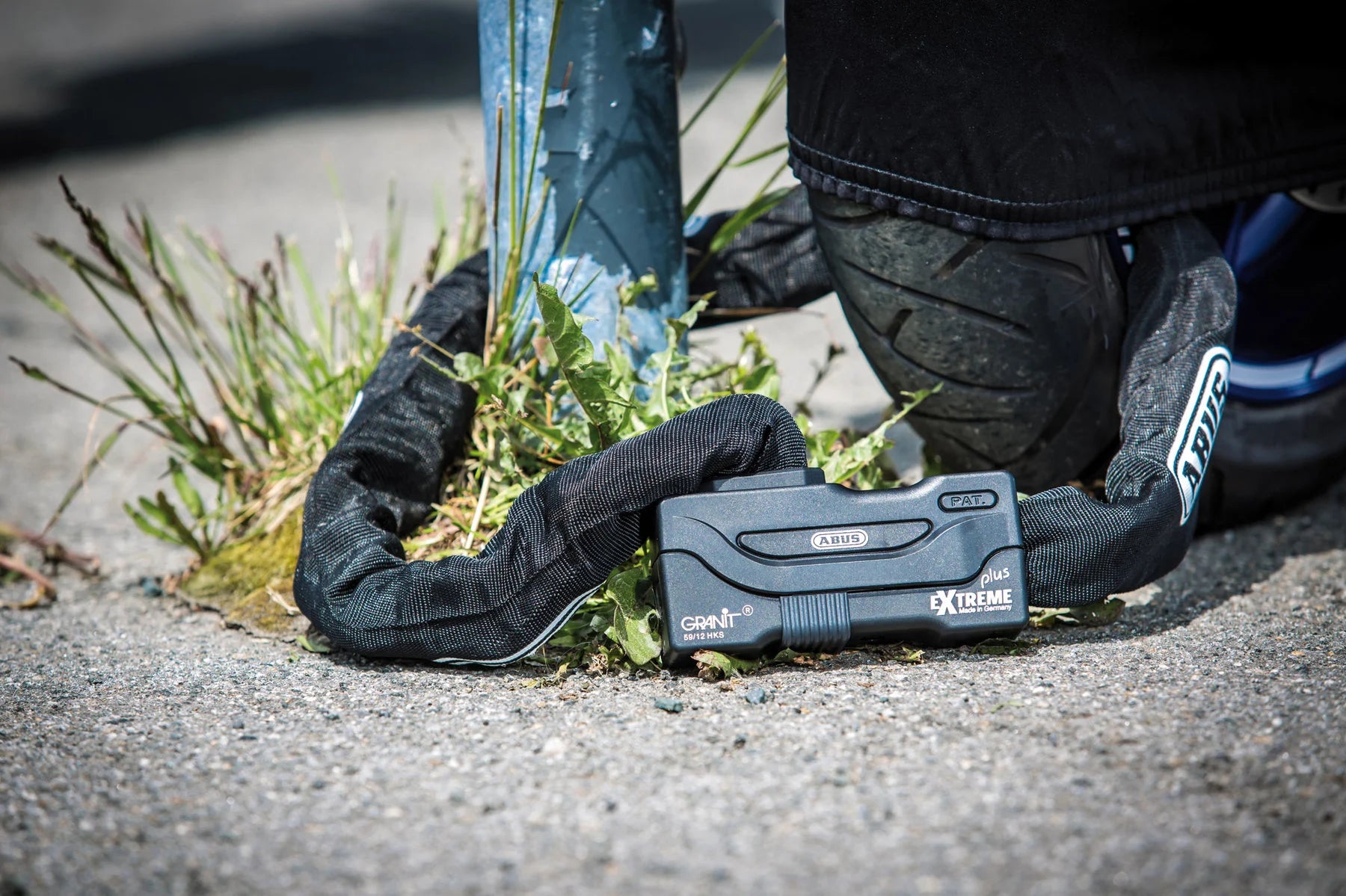 Black chain securing a bike on the ground.