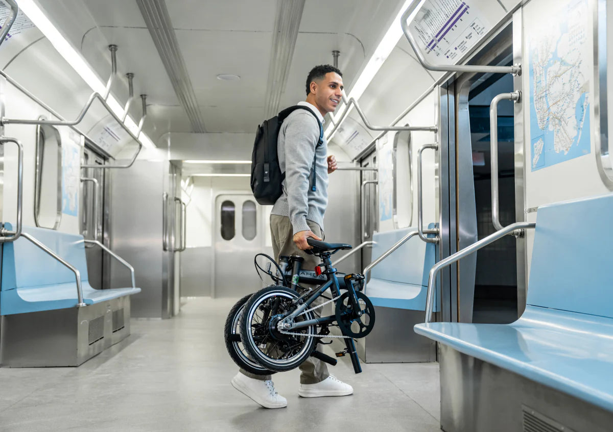 Man with a backpack and folding bike inside a subway train